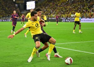 Dortmund's Bensebaini Battles Pain Before Red Card Ends Super Cup Night