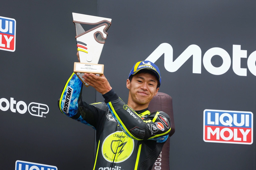 Ai Ogura Yamaha signing holds up a trophy on the podium at the 2026 Sachsenring MotoGP round