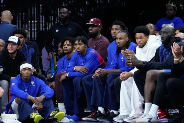 LeBron James watches from the Philadelphia 76ers bench during the first half of a preseason game against the New York Knicks