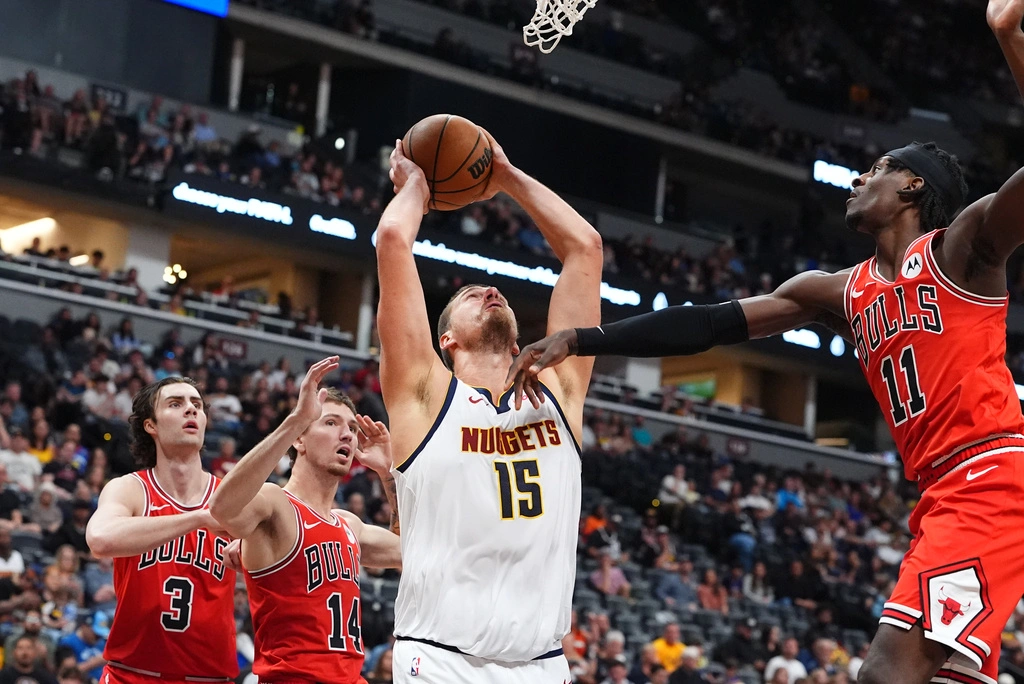 Denver Nuggets center Nikola Jokic goes up for a shot as three Chicago Bulls defenders close in